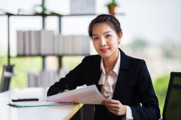 Portrait of Asian businesswoman sitting inside modern office with smile for business and education concept